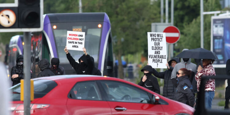 Protesters start to gather, blocking roads in central Belfast, Northern Ireland, in the evening of June 9, 2026. Northern Ireland police said on June 9, 2026 they had arrested a man following what Prime Minister Keir Starmer branded a "sickening" stabbing in Belfast, with graphic video prompting protest calls from UK far-right figures. Video of the June 8, 2026 incident posted on social media networks shows a man straddling another man lying in a street and slashing him several times in the head and neck with a knife in what appears to be an attempted beheading. (Photo by Paul Faith / AFP via Getty Images)