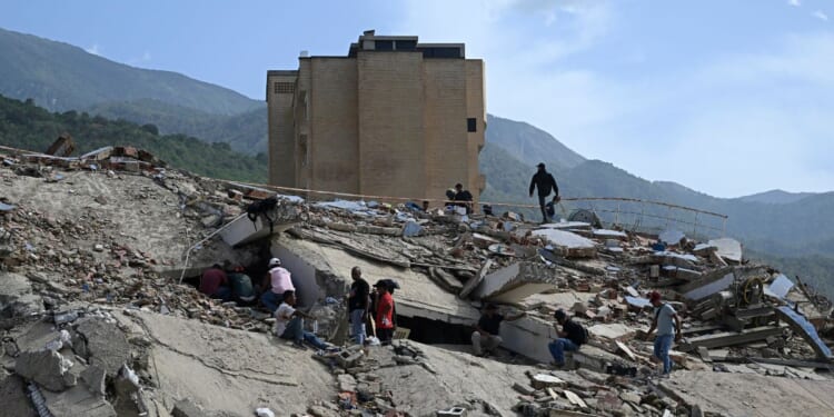 Volunteers search for possible victims amid the rubble following a twin earthquake in Caraballeda, La Guaira state, about 40 km northeast of Caracas, on June 25, 2026.