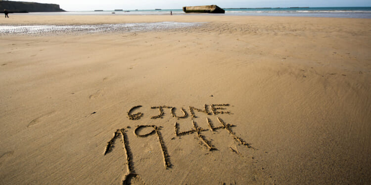 The date 6 June 1944 written in the sand of the beaches of Normandy, France.