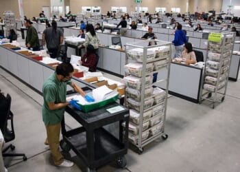 Workers count ballots on June 3 at the ballot processing center in City of Industry, California.