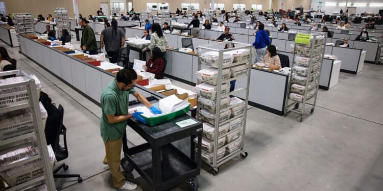 Workers count ballots on June 3 at the ballot processing center in City of Industry, California.