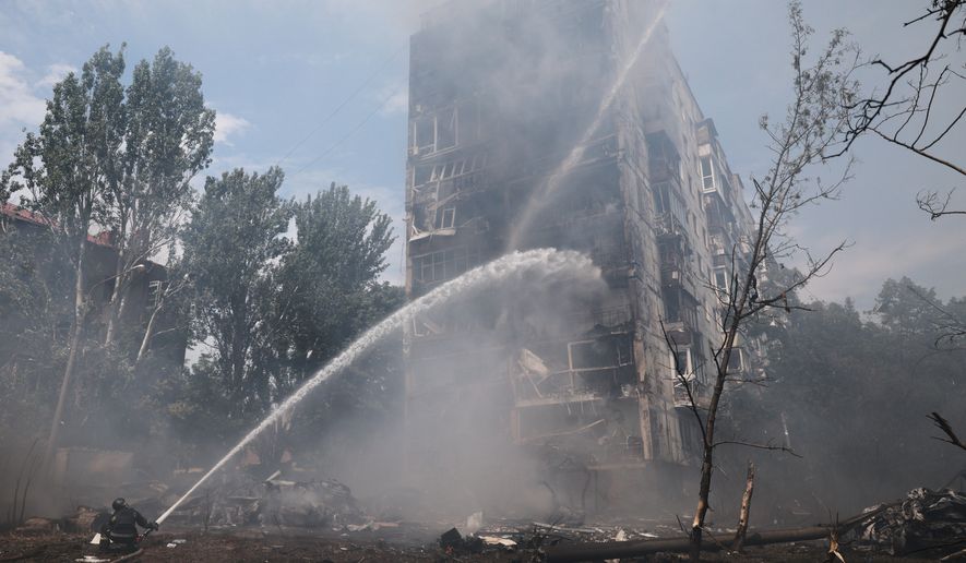 Rescue workers try to put out a fire of a residential building burning after a Russian air guided bomb strike in Zaporizhzhia, Ukraine, Tuesday, July 21, 2026. (AP Photo/Kateryna Klochko)