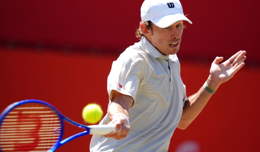 Alex De Minaur of Australia in action against Brandon Nakashima of the US in the men's singles quarterfinal match on day twelve of the Tennis Championships at The Queen's Club, in London, Friday, June 19, 2026. (Adam Davy/PA via AP)
