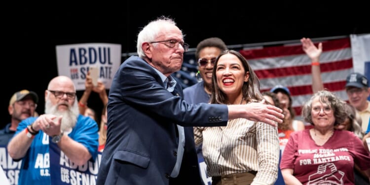 Sen. Bernie Sanders, an Independent from Vermont, greets Rep. Alexandria Ocasio-Cortez, a Democrat from New York, at The People v. The Powerful rally at the Detroit Opera House on July 18, 2026, in Detroit, Michigan.