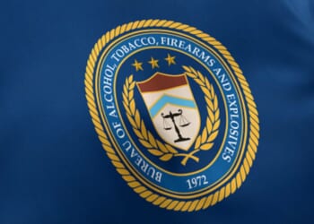 The Bureau of Alcohol, Tobacco, Firearms and Explosives flag waves under white lighting.