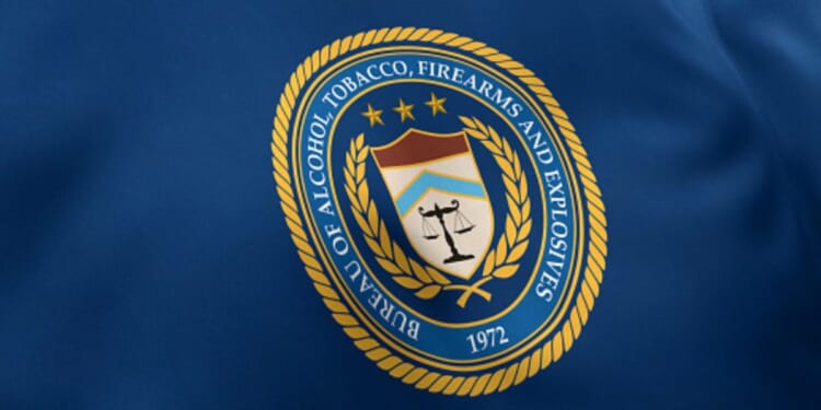 The Bureau of Alcohol, Tobacco, Firearms and Explosives flag waves under white lighting.
