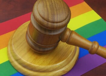 A judge's gavel on a rainbow flag.