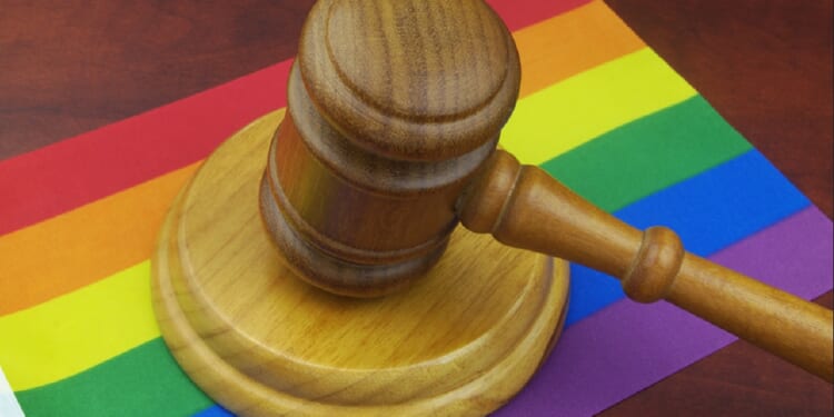 A judge's gavel on a rainbow flag.