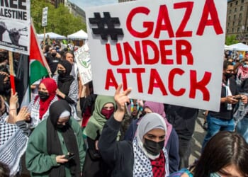 Demonstrators hold signs as thousands gather during a rally to support Palestine at Copley Square in Boston, Massachusetts, on May 15, 2021.