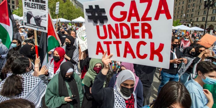 Demonstrators hold signs as thousands gather during a rally to support Palestine at Copley Square in Boston, Massachusetts, on May 15, 2021.
