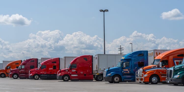 Semi-trucks parked in a lot at rest stop on the Pennsylvania Turnpike in Somerset, Pennsylvania, on July 23, 2023.