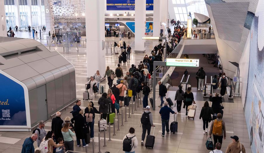 People wait in line at a Transportation Security Administration (TSA) security checkpoint at LaGuardia Airport in the Queens borough of New York, Nov. 9, 2025. (AP Photo/Adam Gray, File)