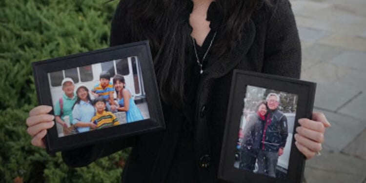 Grace Jin Drexel stands with photos of her father, Ezra Jin, on October 30, 2025 in Washington, D.C. during an interview.