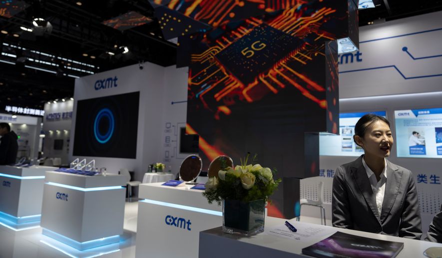 A worker at the booth for Chinese DRAM producer ChangXin Memory Technologies, also known as CXMT, waits for visitors at the 21st China International Semiconductor Expo in Beijing, Nov. 20, 2024. (AP Photo/Ng Han Guan, File)