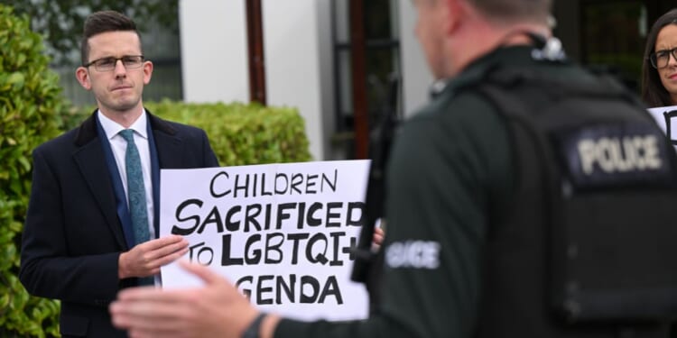 Members of the family of Enoch Burke, a teacher at the center of a case regarding pronoun usage, protest outside the La Mon hotel in Comber, Northern Ireland on Sept. 20, 2025.