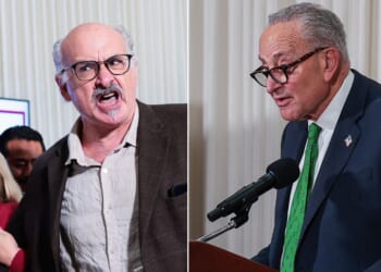 A protester identified as Sam Husseini, left, was escorted out of a news conference where Sen. Chuck Schumer, right, a New York Democrat, was trying to speak.