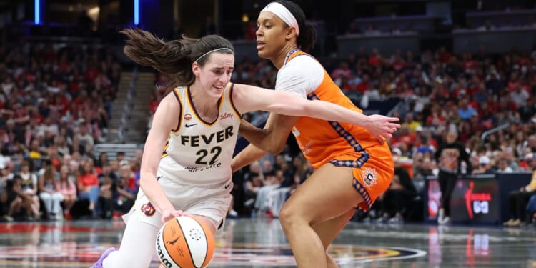 Caitlin Clark of the Indiana Fever dribbles the ball while defended by Nell Angloma of the Connecticut Sun at Gainbridge Fieldhouse on July 22, 2026, in Indianapolis, Indiana.