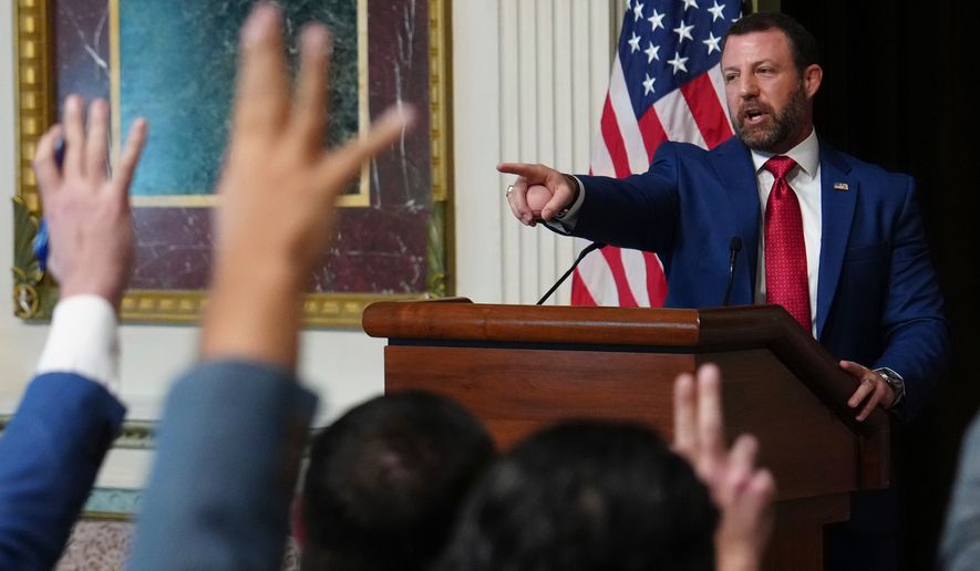 Reporters raise their hands as Homeland Security Secretary Markwayne Mullin speaks in the Indian Treaty Room at the Eisenhower Executive Office Building on the White House campus, Friday, July 17, 2026, in Washington. (AP Photo/Julia Demaree Nikhinson)