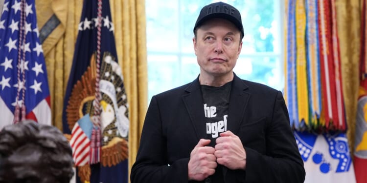 Tesla CEO Elon Musk listens as President Donald Trump speaks to reporters in the Oval Office of the White House on May 30, 2025, in Washington, D.C.