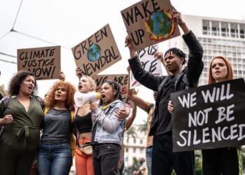 Protesters holding signs during a demonstration for environmentalism.