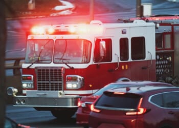 A stock photo of a fire engine with lights flashing.