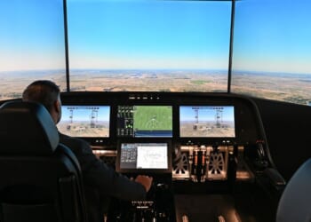 A man sits inside the cockpit of a flight simulator for the Overture Supersonic Airliner at the Boom Supersonic exhibition hall at Farnborough International Exhibition in Farnborough, England, on July 23, 2024.