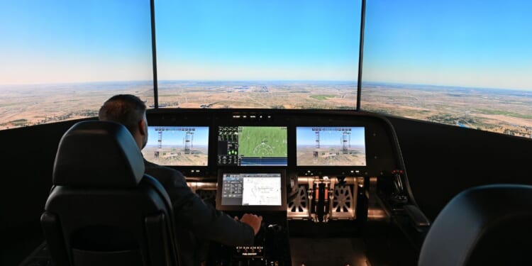 A man sits inside the cockpit of a flight simulator for the Overture Supersonic Airliner at the Boom Supersonic exhibition hall at Farnborough International Exhibition in Farnborough, England, on July 23, 2024.