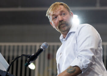 Democrat Graham Platner looks off to the side as he speaks at a podium.