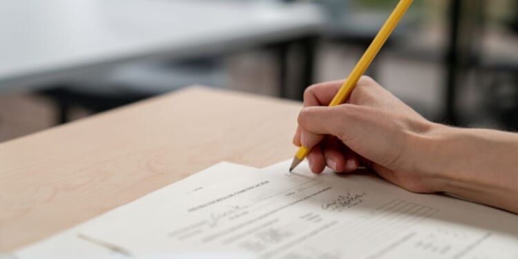 A close-up view of a university teacher grading an exam.