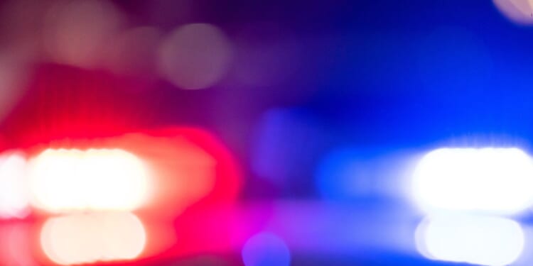 A police car with flashing lights at night.