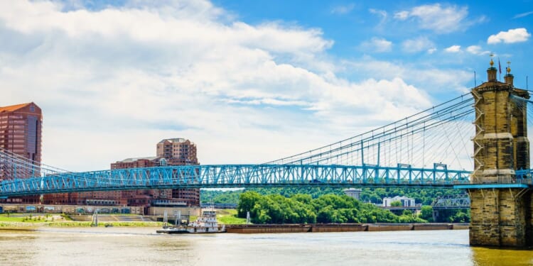 Barges are going under the Roebling Bridge in Cincinnati, Ohio.