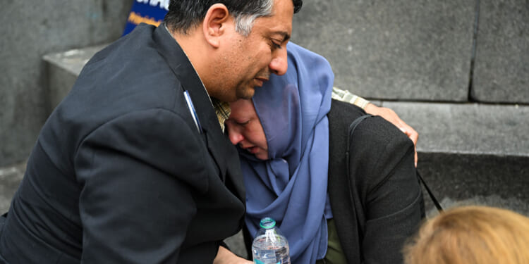 Two people cry during the memorial as hundreds of pro-Palestinian protesters gathered in Washington.