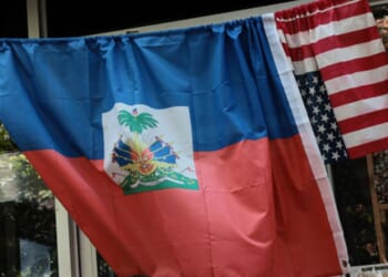 An American and Haitian flag hang on a bar outside a shop on June 25, 2026.
