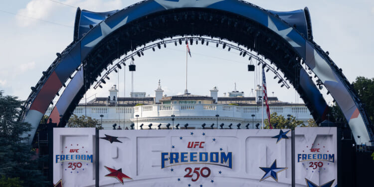 Large decorated stage with UFC Freedom 250 banners in front of the White House, featuring stars and patriotic colors.