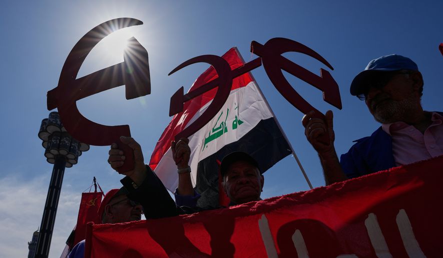 Supporters of the Iraqi Communist Party hold a symbolic hammer and sickle as they take part in the May Day celebration in Baghdad, Iraq, Friday, May 1, 2026. (AP Photo/Hadi Mizban) ** FILE **