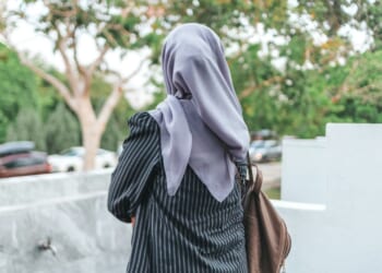 Woman wearing a hijab walks away from camera.