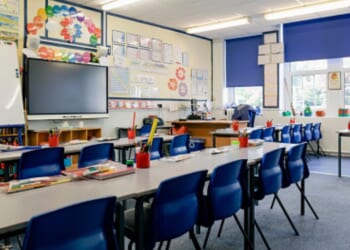 An empty classroom is drenched in sunlight during a bright afternoon.