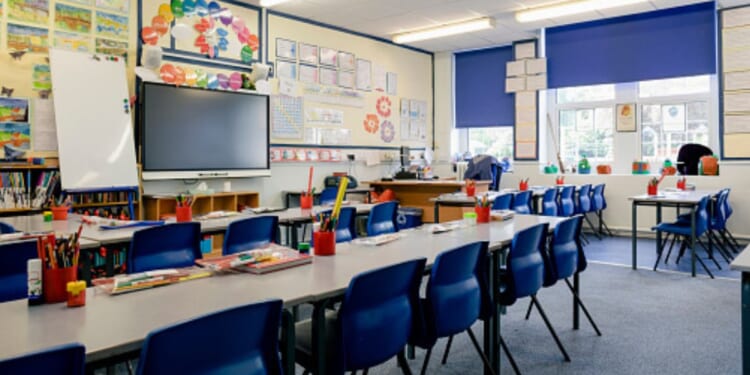 An empty classroom is drenched in sunlight during a bright afternoon.