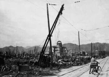 A man wheels his bicycle thorough Hiroshima, Japan, days after the city was leveled by an atomic bomb blast on Aug. 6, 1945.