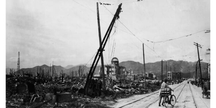 A man wheels his bicycle thorough Hiroshima, Japan, days after the city was leveled by an atomic bomb blast on Aug. 6, 1945.