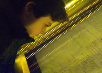 Close-up of a boy looking through a glass frame at the U.S. Constitution.