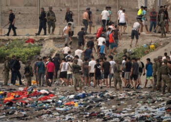 Spanish soldiers direct migrants back to Morocco after they crossed the border to enter Spain's north Africa's Ceuta territory on Thursday. In recent days, a total of around 60,000 migrants have crossed into the territory, whose population is 80,000.