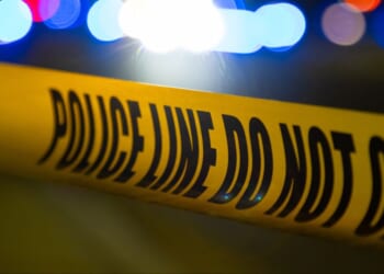 A crime scene is blocked off by yellow police tape.