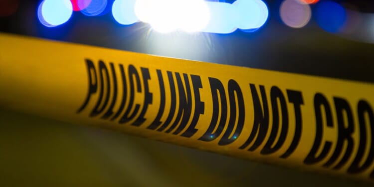 A crime scene is blocked off by yellow police tape.