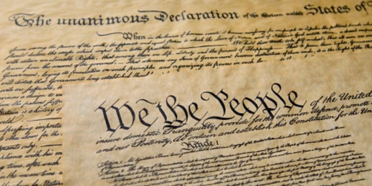 Pages of the Constitution are visible under warm lighting.