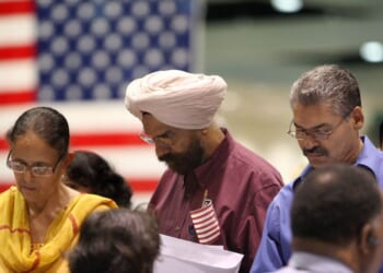 Amrik Sidhu and his wife Harjinder Sidhu, both Sikhs from India, apply for their passports after gaining U.S. citizenship as 18,418 people are sworn in as citizens during naturalization ceremonies at the Los Angeles Convention Center on Aug. 28, 2008, in Los Angeles, California.