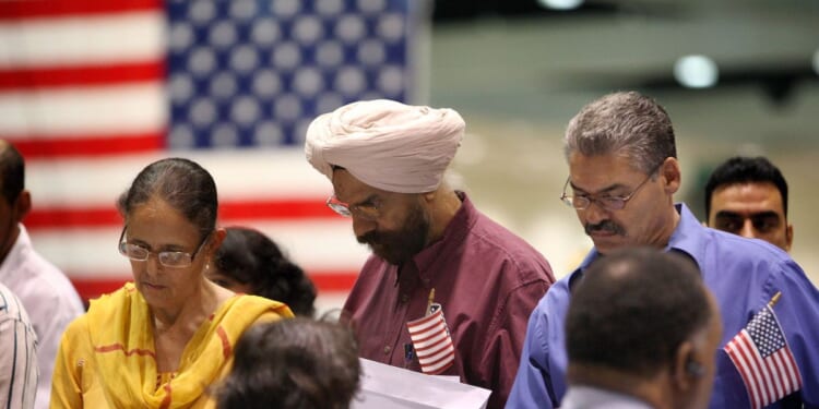 Amrik Sidhu and his wife Harjinder Sidhu, both Sikhs from India, apply for their passports after gaining U.S. citizenship as 18,418 people are sworn in as citizens during naturalization ceremonies at the Los Angeles Convention Center on Aug. 28, 2008, in Los Angeles, California.