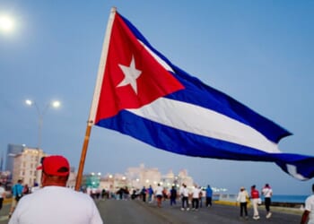 A man walks with a Cuban flag alongside the Havana waterfront on May 1, 2026.