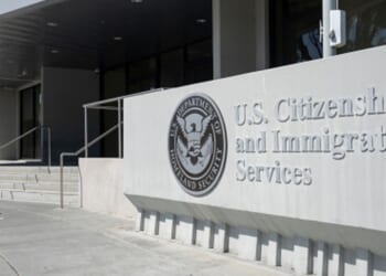 A concrete structure with the logo of United States Citizen and Immigration Services is pictured outside a glass building on April 30, 2022 in Santa Clara, California.