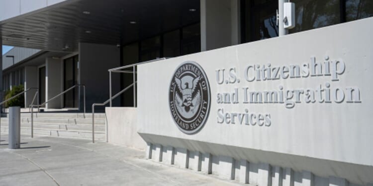 A concrete structure with the logo of United States Citizen and Immigration Services is pictured outside a glass building on April 30, 2022 in Santa Clara, California.